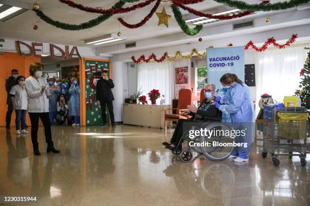 Attendees applaud as Josefa Perez, a resident at the Feixa Llarga nursing home, second right, receives a dose of the Pfizer-BioNTech Covid-19 vaccine...