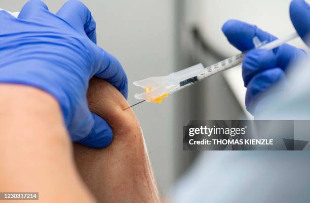 Man gets the injection with the Pfizer-BioNTech Covid-19 vaccine at the corona vaccination centre at the Robert Bosch hospital in Stuttgart, southern...