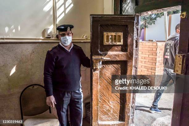 This picture taken during a government-guided tour on December 27, 2020 shows a policeman opening the gate to al-Qanatir women's prison, at the tip...