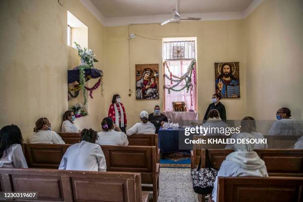 This picture taken during a government-guided tour on December 27, 2020 shows inmates attending a chapel with a Coptic Orthodox clergyman and...