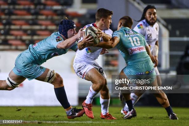 Toulon's French fly-half Louis Carbonel is tackled by Clermont's New Zealander fly-half Tim Nanai Williams and Clermont's French wing Bastien...