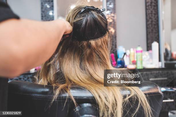 An employee puts extensions into a customer's hair at a beauty salon in Caracas, Venezuela, on Saturday, March 7, 2020. Venezuela is seeing an annual...