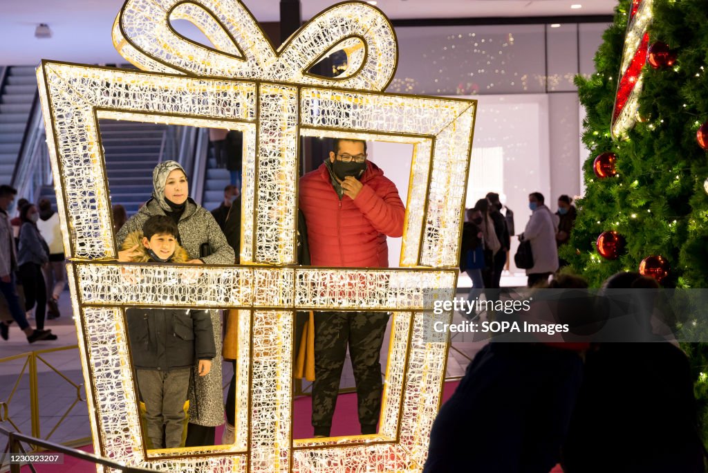 People pose for a photo next to Christmas decorations at the...