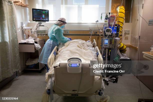 Registered Nurse Joan Pung, works with a covid positive patients room inside the ICU at Providence St. Jude Medical Center Christmas Day on Friday,...