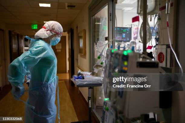 Registered Nurse Joan Pung, right, dawns her isolation gowns in the hallway inside the ICU at Providence St. Jude Medical Center Christmas Day on...