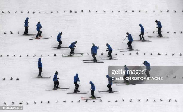 Helpers prepare the hill ahead the training jump of the Four-Hills Ski Jumping tournament in Oberstdorf, southern Germany, on December 28, 2020. -...