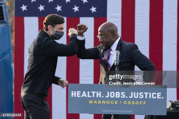 Georgia Democratic Senate candidates Raphael Warnock and Jon Ossoff bump elbows during a "It's Time to Vote" drive-in rally on December 28, 2020 in...