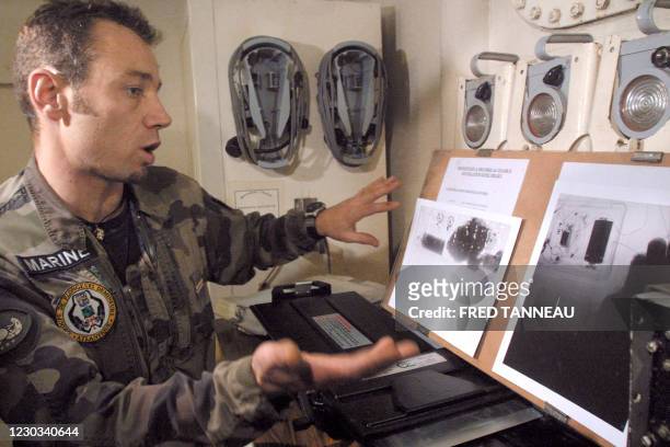 Un plongeur-démineur de la Marine nationale, donne des explications sur des radios prises aux rayons X d'une fausse bombe, le 10 novembre 2005 à bord...
