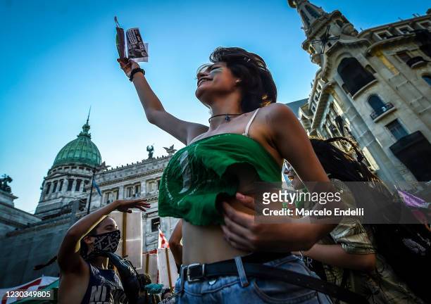Pro-choice demonstrator wearing a green kerchief shouts slogans outside of the National Congress as senators decide on legalization of abortion on...