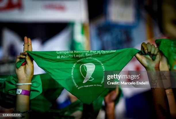 Pro-choice demonstrator raises a green kerchief outside the National Congress as senators decide on legalization of abortion on December 29, 2020 in...