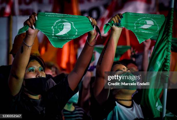 Pro-choice demonstrators raise green kerchiefs outside the National Congress as senators decide on legalization of abortion on December 29, 2020 in...