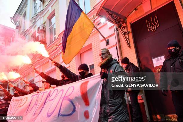 Activists burn flares and smoke bomb during a rally in front of the High Anti-Corruption Court building, in Kiev, on December 30, 2020 to protest...