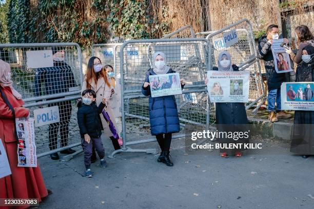 People come out from Chinese consulate as supporters and members of the Muslim Uighur minority hold placards as they demonstrate in front of the...