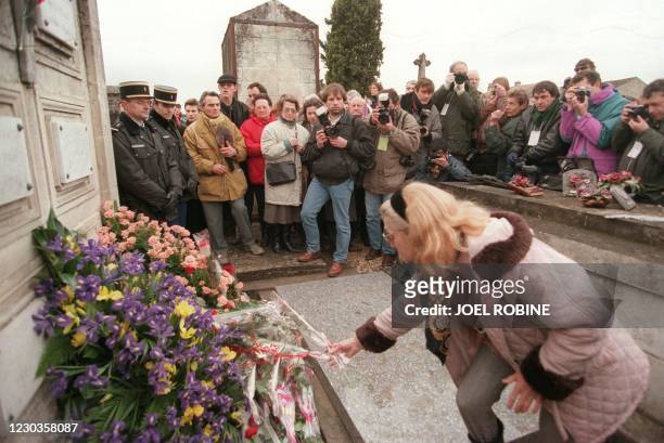 Photo du 11 janvier 1996 d'une femme posant une fleur sur la tombe de François Mitterrand, dans le cimetière de Grand Maison à Jarnac, où l'ancien...