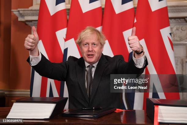 Prime Minister, Boris Johnson gives a thumbs up gesture after signing the Brexit trade deal with the EU in number 10 Downing Street on December 30,...