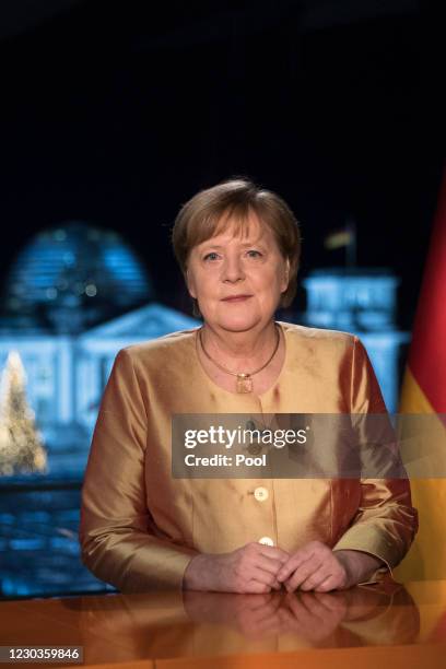 German Chancellor Angela Merkel poses for photographs after the television recording of her annual New Year's speech at the chancellery on December...