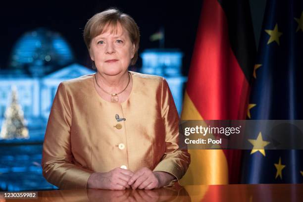 German Chancellor Angela Merkel poses for photographs after the television recording of her annual New Year's speech at the chancellery on December...