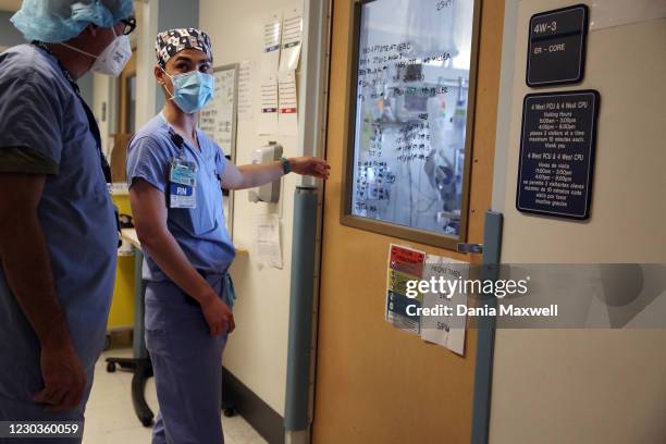 Nurse looks at charting on the window of a room where Covid-19 patients are being treated in a makeshift ICU wing on the West Oeste at Harbor UCLA...