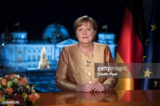 German Chancellor Angela Merkel poses for photographs after the television recording of her annual New Year's speech at the chancellery on December...