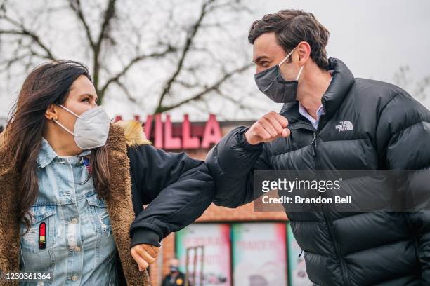 Democratic Senate candidate Jon Ossoff elbow greets a woman at a Latino meet and greet and literature distribution rally on December 30, 2020 in...