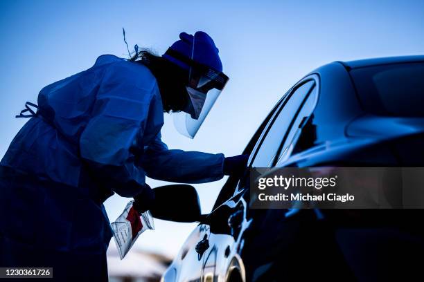 Check Colorado site tester Kellen Taylor administers a COVID test at Echo Park Stadium on December 30, 2020 in Parker, Colorado. The site is one of...