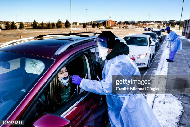 Check Colorado site tester Bradford Christopher administers a COVID test at Echo Park Stadium on December 30, 2020 in Parker, Colorado. The site is...
