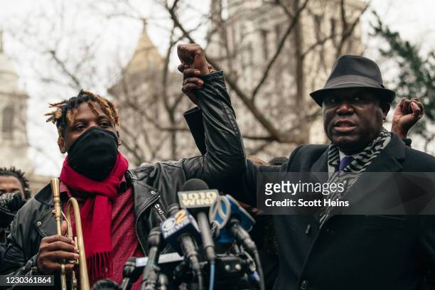 Jazz musician Keyon Harrold, left, and attorney Benjamin Crump, right, hold hands at a press conference held in lower Manhattan on December 30, 2020...