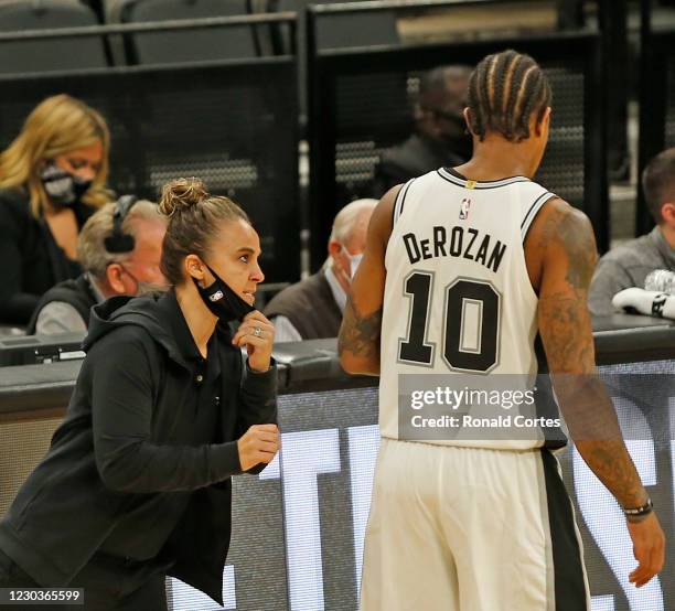 DeMar DeRozan of the San Antonio Spurs receives instruction from assistant coach Becky Hammon who was filling for an ejected Gregg Popvich during...