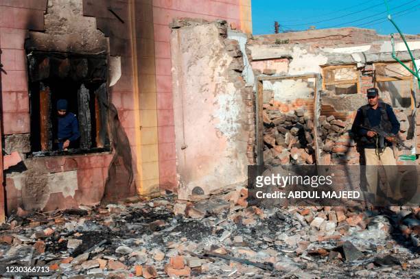 Policemen inspect the burnt Hindu temple a day after a mob attack in a remote village in Karak district, some 160 kms southeast of Peshawar on...