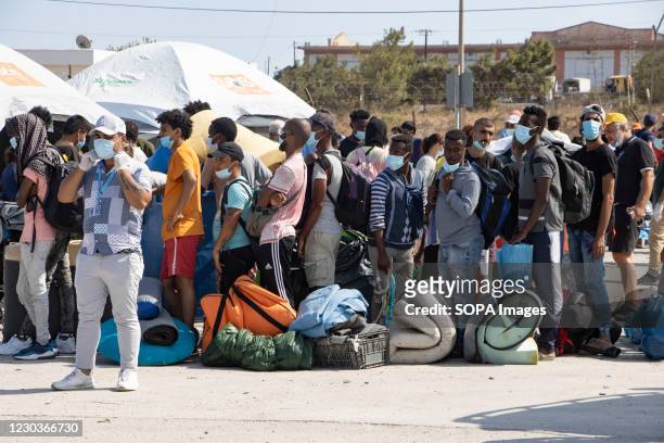 Thousands of asylum seekers wait in a line to register and enter the new Kara Tepe refugee camp north of Mytilene, the capital of the island of...