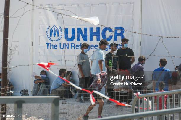 New Temporary Refugee Camp in Kara Tepe - Mavrovouni with large white tents having the UNHCR or UNICEF logo and asylum seekers waiting in line for...