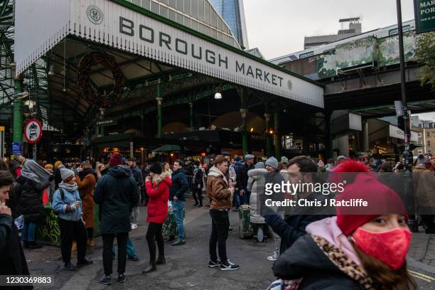 People shop, eat and drink at Borough Market on December 31, 2020 in London, United Kingdom.