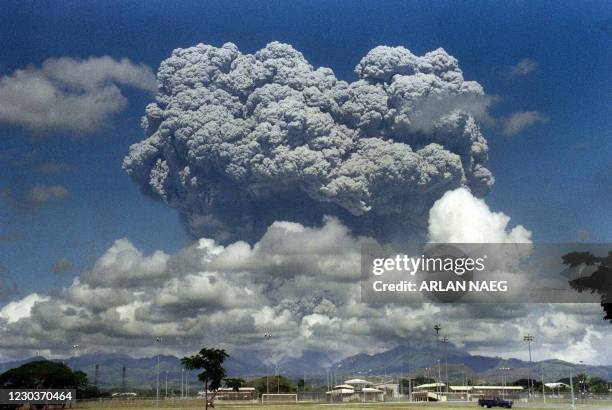 Giant volcanic mushroom cloud explodes some 20 kilometers high from Mount Pinatubo above almost deserted US Clark Air Base, on June 12, 1991 followed...