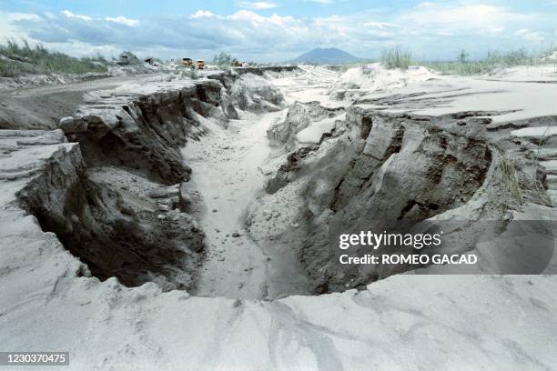 Bulldozers rush to repair collapsed Taug Dike, on June 29, 1991 as lake of trapped volcanic mudflow lies on the slopes of Mount Pinatubo volcano...