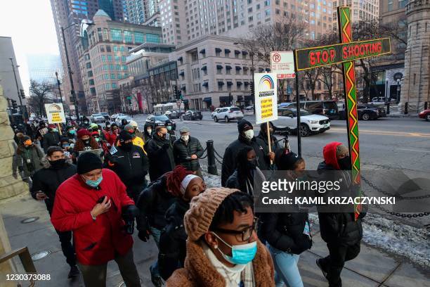 People walk during an anti gun violence march on the Magnificent Mile in Chicago, Illinois, on December 31, 2020. - In Chicago, murders for 2020...