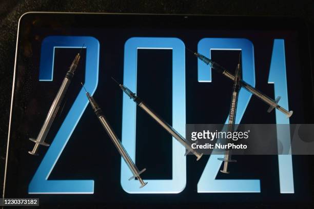 An illustrative image of medical syringes in front of 2021 image displayed on a screen. On Thursday, December 31 in Dublin, Ireland.