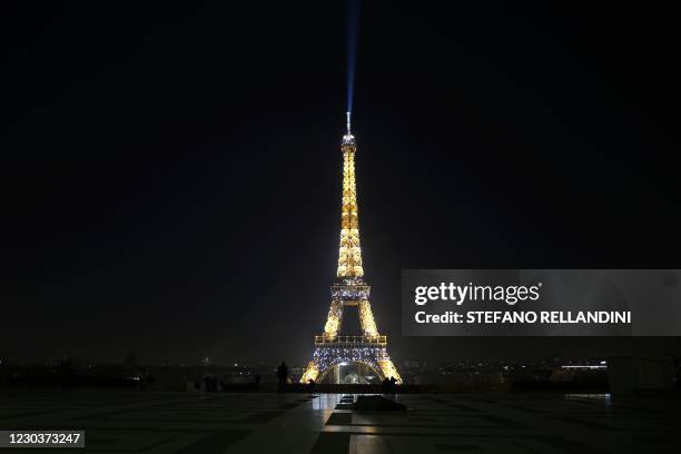 This picture shows the illuminated Eiffel Tower during the New Year's Eve as a 8:00 pm-6:00 am curfew is implemented in France to avoid a third wave...