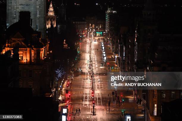 Less than an hour to midnight, a near-deserted Princes Street is pictured in Edinburgh late on New Year's Eve, December 31 as the message to stay at...
