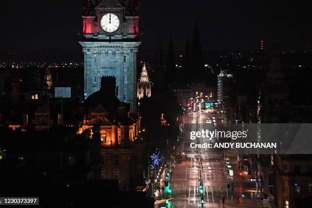 Near-deserted Princes Street in Edinburgh is pictured as the time passes midnight, shown on the Balmoral Hotel clock early on January 1, 2021 in...