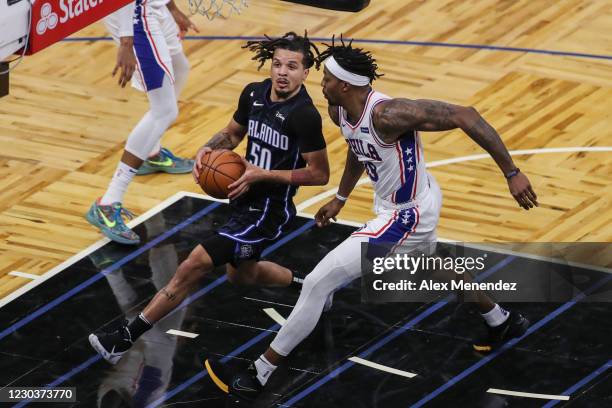 Cole Anthony of the Orlando Magic drives to the net against Dwight Howard of the Philadelphia 76ers at Amway Center on December 31, 2020 in Orlando,...