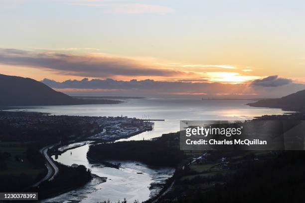 The sun rises over Warrenpoint harbour in the north and Carlingford in the south of Ireland which are separated by the Newry river on January 1, 2021...
