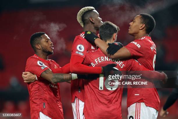 Manchester United's Portuguese midfielder Bruno Fernandes celebrates with teammates after scoring their second goal from the penalty spot during the...