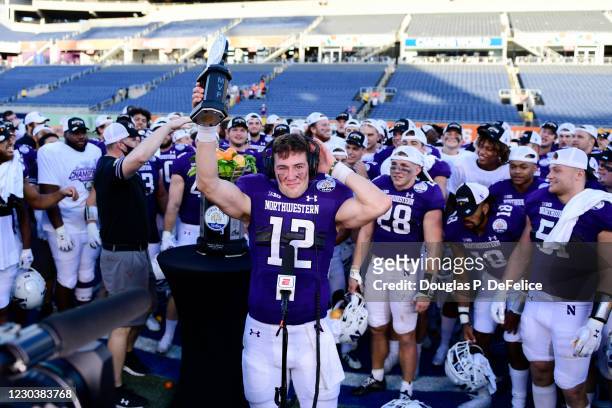 Peyton Ramsey of the Northwestern Wildcats raises the MVP trophy after defeating the Auburn Tigers to win the Vrbo Citrus Bowl at Camping World...