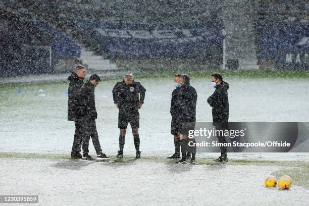 From left to right: West Bromwich Albion manager Sam Allardyce, Arsenal manager Mikel Arteta and the match officials stand in the snow ahead of the...