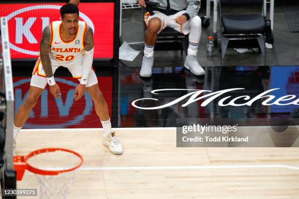 John Collins of the Atlanta Hawks looks on from the baseline during the first half against the Cleveland Cavaliers at State Farm Arena on January 2,...