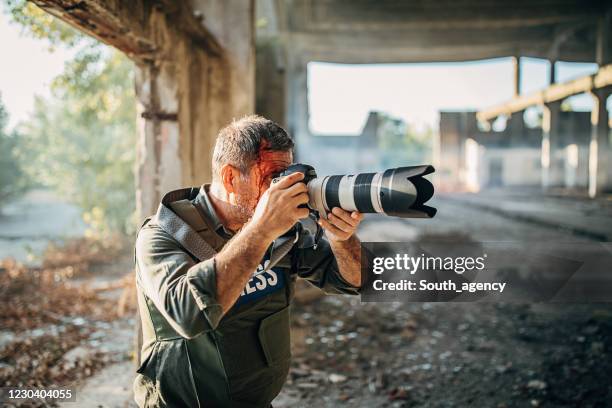 fotógrafo de guerra hombre herido en edificio abandonado - reportaje imágenes fotografías e imágenes de stock