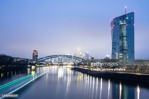 January 2021, Hessen, Frankfurt/Main: The skyscrapers of Frankfurt's banking skyline rise out of the gathering darkness behind the European Central...
