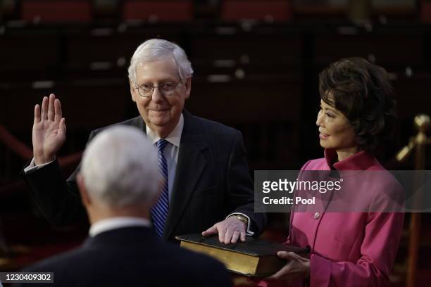 Senate Majority Leader Mitch McConnell is sworn-in by U.S. Vice President Mike Pence, with Elaine Chao, U.S. Secretary of Transportation, McConnell's...