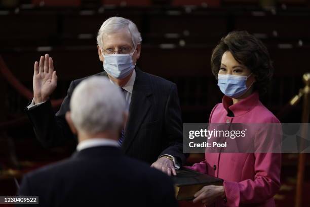 Senate Majority Leader Mitch McConnell is sworn-in by U.S. Vice President Mike Pence, with Elaine Chao, U.S. Secretary of Transportation, McConnell's...