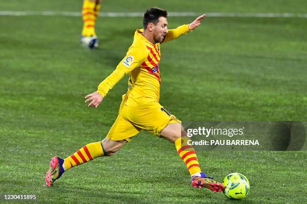 Barcelona's Argentinian forward Lionel Messi runs with the ball during the Spanish League football match between Huesca and Barcelona at the El...